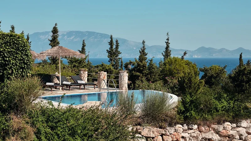Villa Solar’s private pool beside rustic stone architecture and gardens with the sea beyond